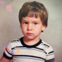 A young child with short hair wearing a striped shirt.